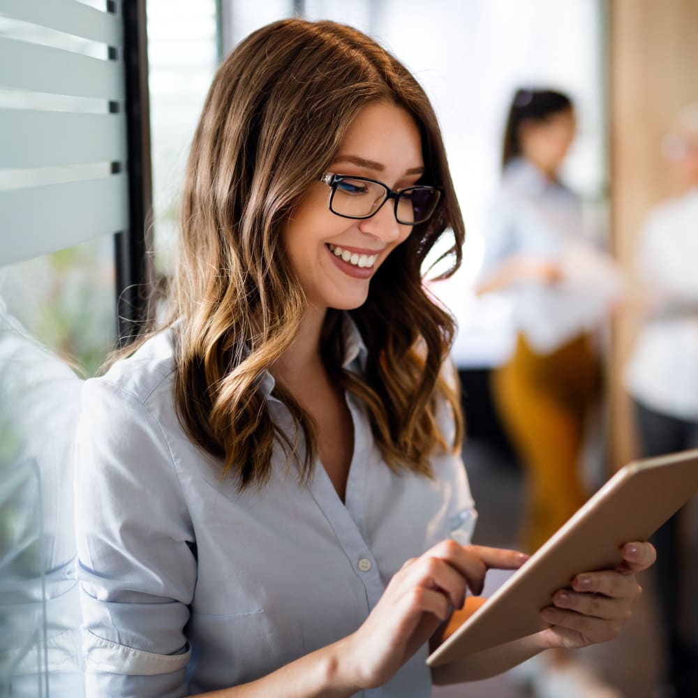 A woman with shoulder length hair is using a tablet.
